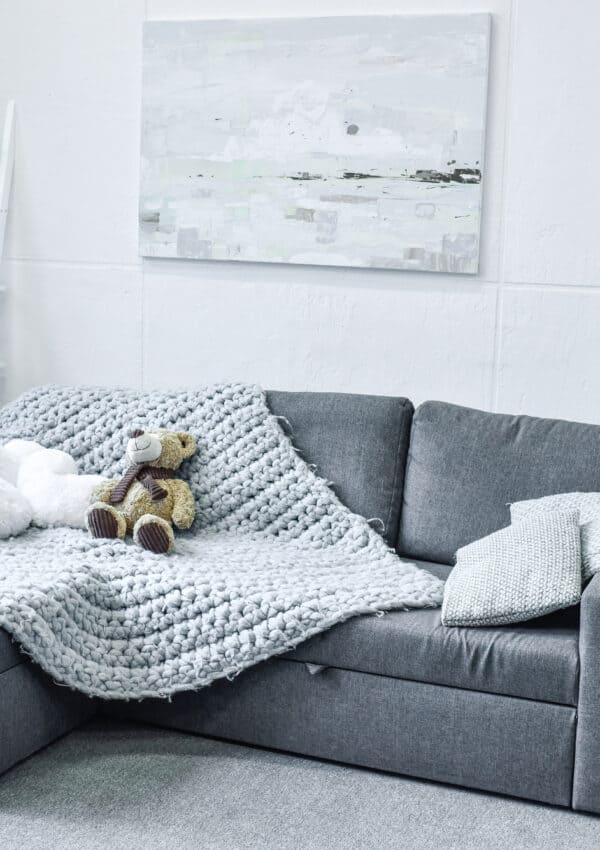 Tidy gray sofa with throw and ladder