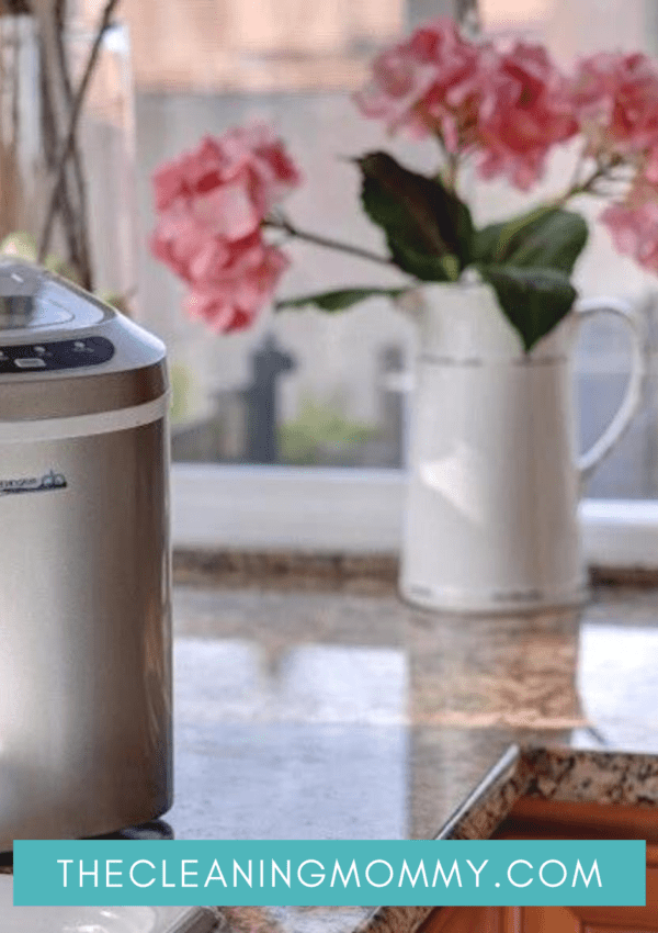 stainless steel countertop ice maker with pink flowers behind