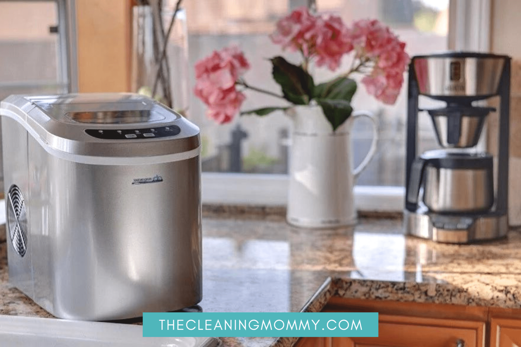 stainless steel countertop ice maker with pink flowers behind