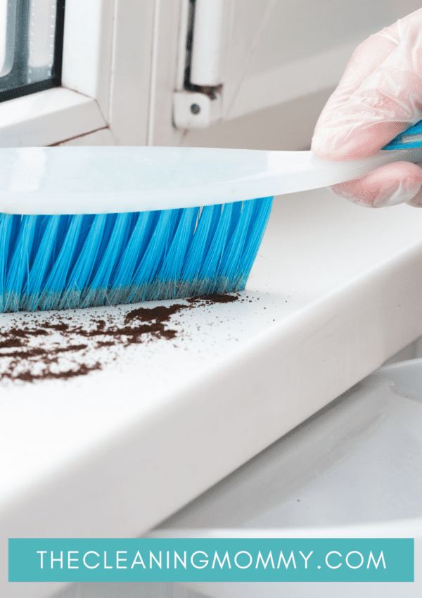 Hand brush cleaning dirt off window sill