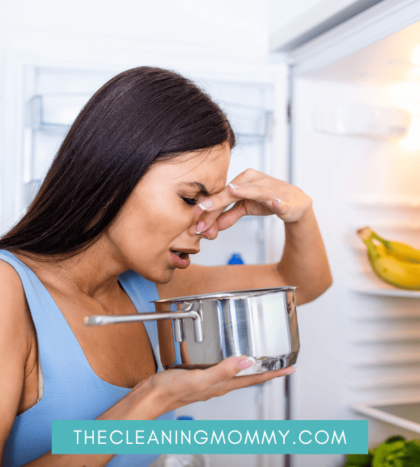 Woman holding nose smell pot in fridge