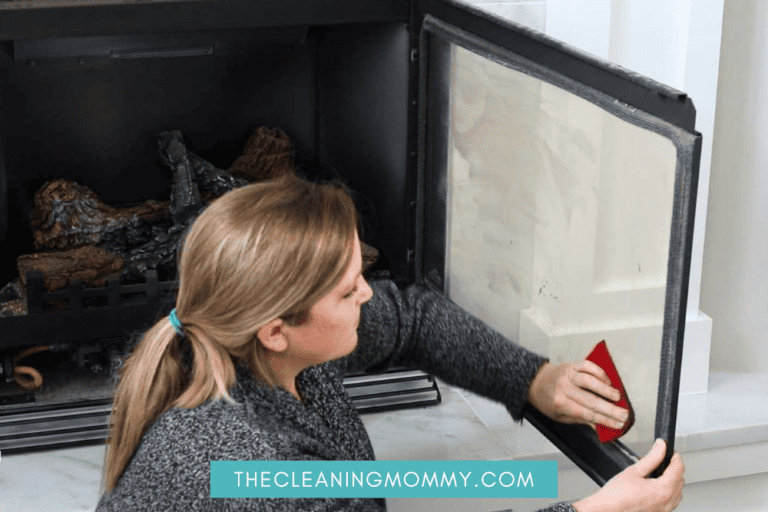 woman cleaning burning wood stove glass door