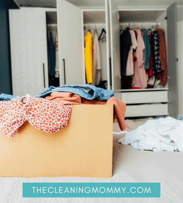 Box of clothes you are decluttering in front of closet