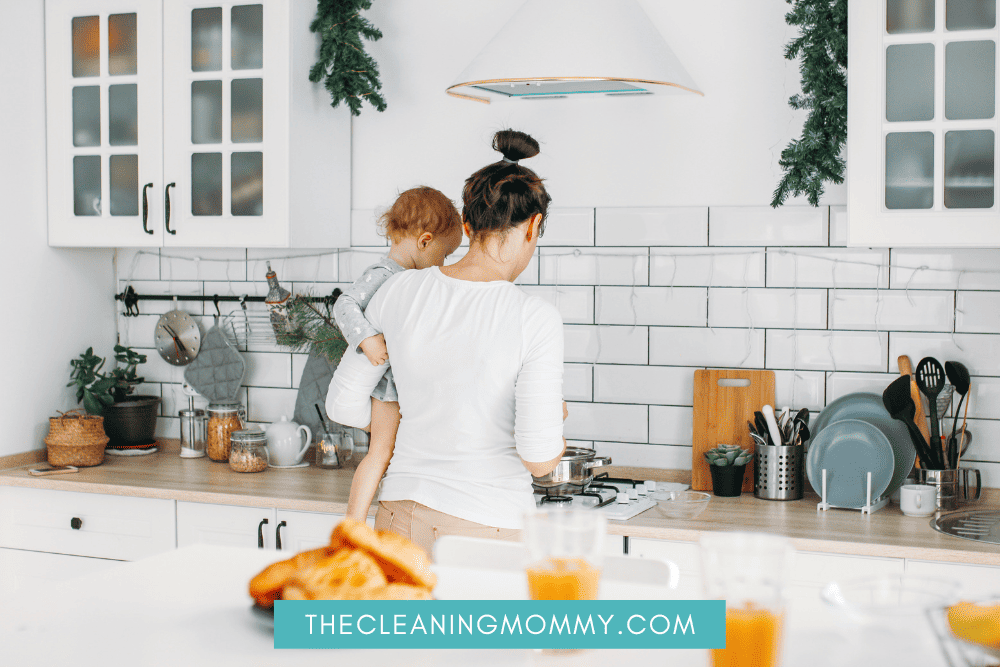 Mom in white carrying baby in kitchen