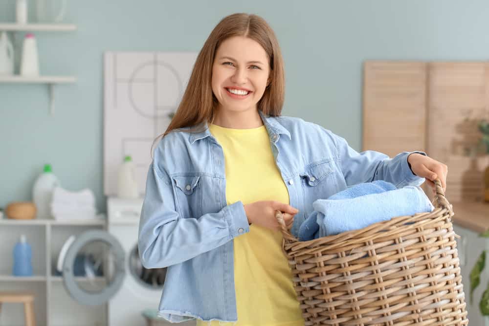 Mom in blue shirt holding laundry basket